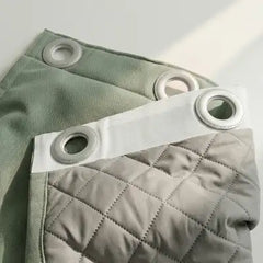 Photographie d'un client Kurtens présentant un rideau sur mesure vert avec oeillets et revers ouaté isolant 