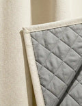 Vue côté doublure matelassée thermique et phonique du rideau sur mesure beige Kurtens, finition piquée en losanges