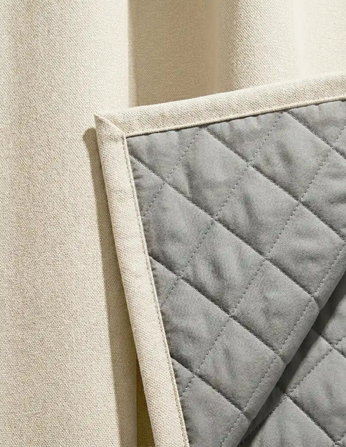 Vue côté doublure matelassée thermique et phonique du rideau sur mesure beige Kurtens, finition piquée en losanges