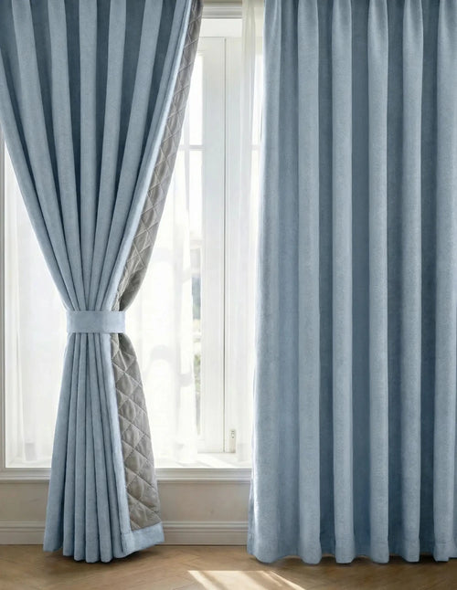 Rideaux sur mesure bleu ciel Kurtens devant fenêtre avec embrasse, voilage blanc et doublure matelassée grise apparente