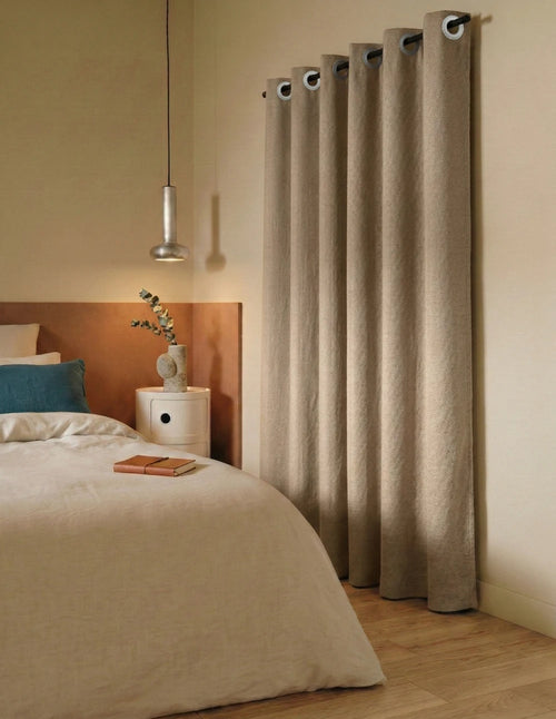 Rideau sur mesure crème Kurtens à œillets dans une chambre à coucher cosy avec tête de lit bois et suspension design