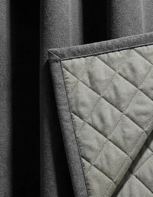 Gros plan sur la doublure matelassée en losanges du rideau gris anthracite Kurtens, illustrant la structure isolante thermique et phonique