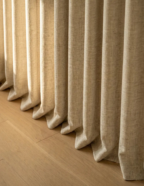 Détail du tombé du rideau occultant jaune cassant sur le parquet