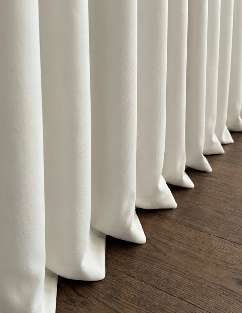 Rideau anti-bruit blanc cassé pleine hauteur dans un intérieur lumineux