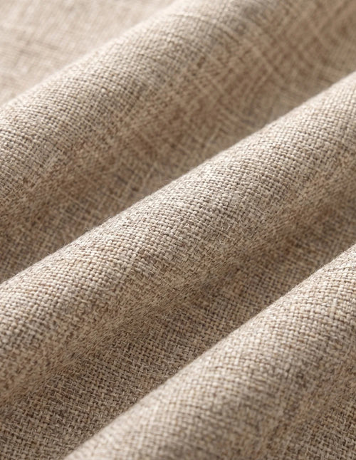 Rideau tamisant beige effet lin tiré pleine hauteur devant une fenêtre dans une chambre claire en bois