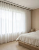 Rideau tamisant blanc effet lin diffusant la lumière du jour dans une chambre lumineuse