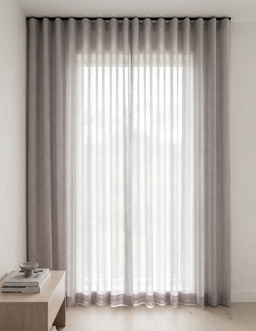 Rideau tamisant gris mauve effet lin diffusant la lumière du jour dans une chambre lumineuse