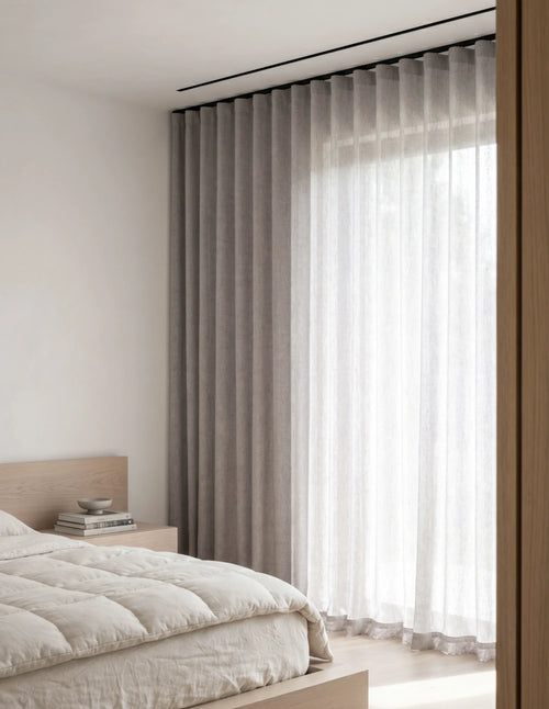 Tissu du rideau tamisant gris mauve effet lin drapé sur une chaise en bois, lumière du jour traversant la trame