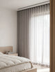 Tissu du rideau tamisant gris mauve effet lin drapé sur une chaise en bois, lumière du jour traversant la trame