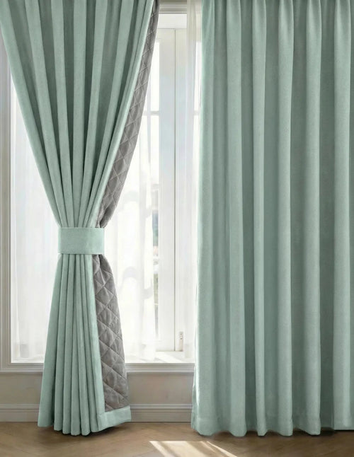 Photographie d'un Rideau sur mesure vert menthe Kurtens avec embrasse et doublure matelassée, fenêtre baignée de lumière