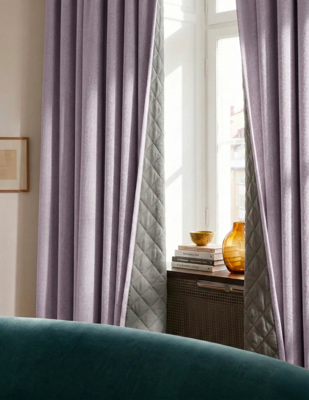 Rideaux sur mesure lilas Kurtens avec doublure matelassée dans un salon élégant, fenêtre lumineuse et fauteuil velours