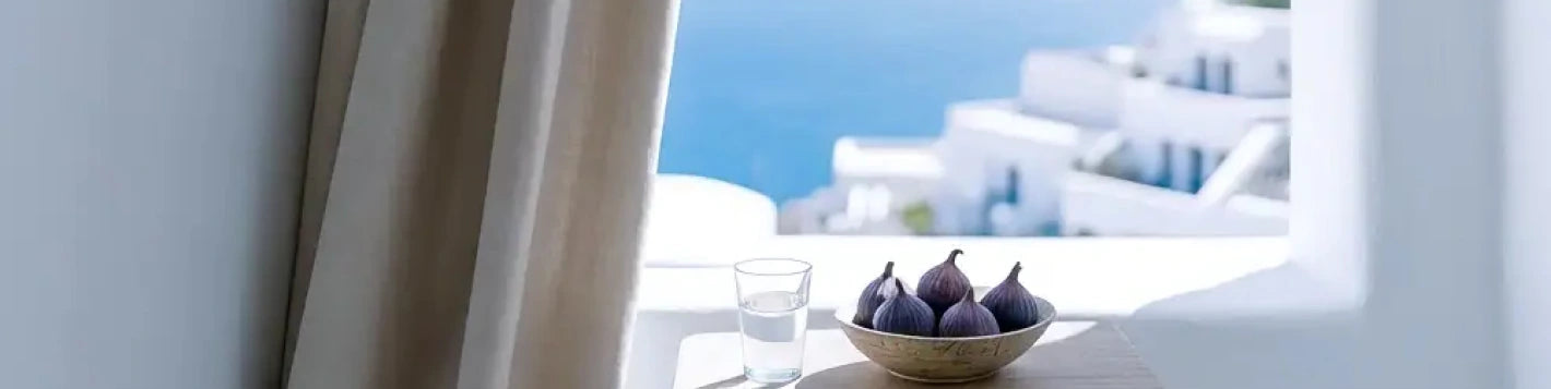 Bannière voilage sur mesure blanc Kurtens sur terrasse grecque avec vue mer et figues, esprit vacances