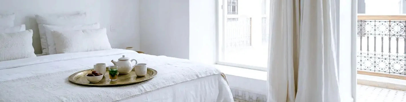 Bannière rideau sur mesure blanc voilage Kurtens dans une chambre parisienne ensoleillée, esprit petit-déjeuner