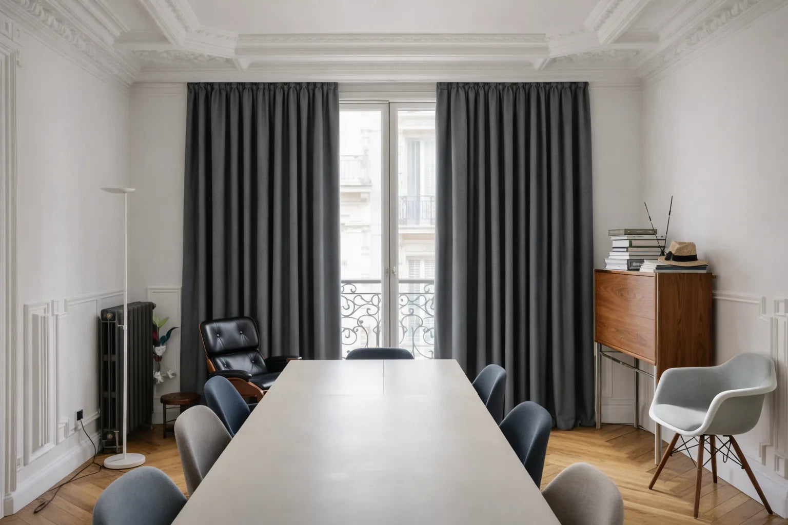 Rideaux sur mesure gris anthracite Kurtens dans une salle à manger haussmannienne avec grande table blanche, bureau